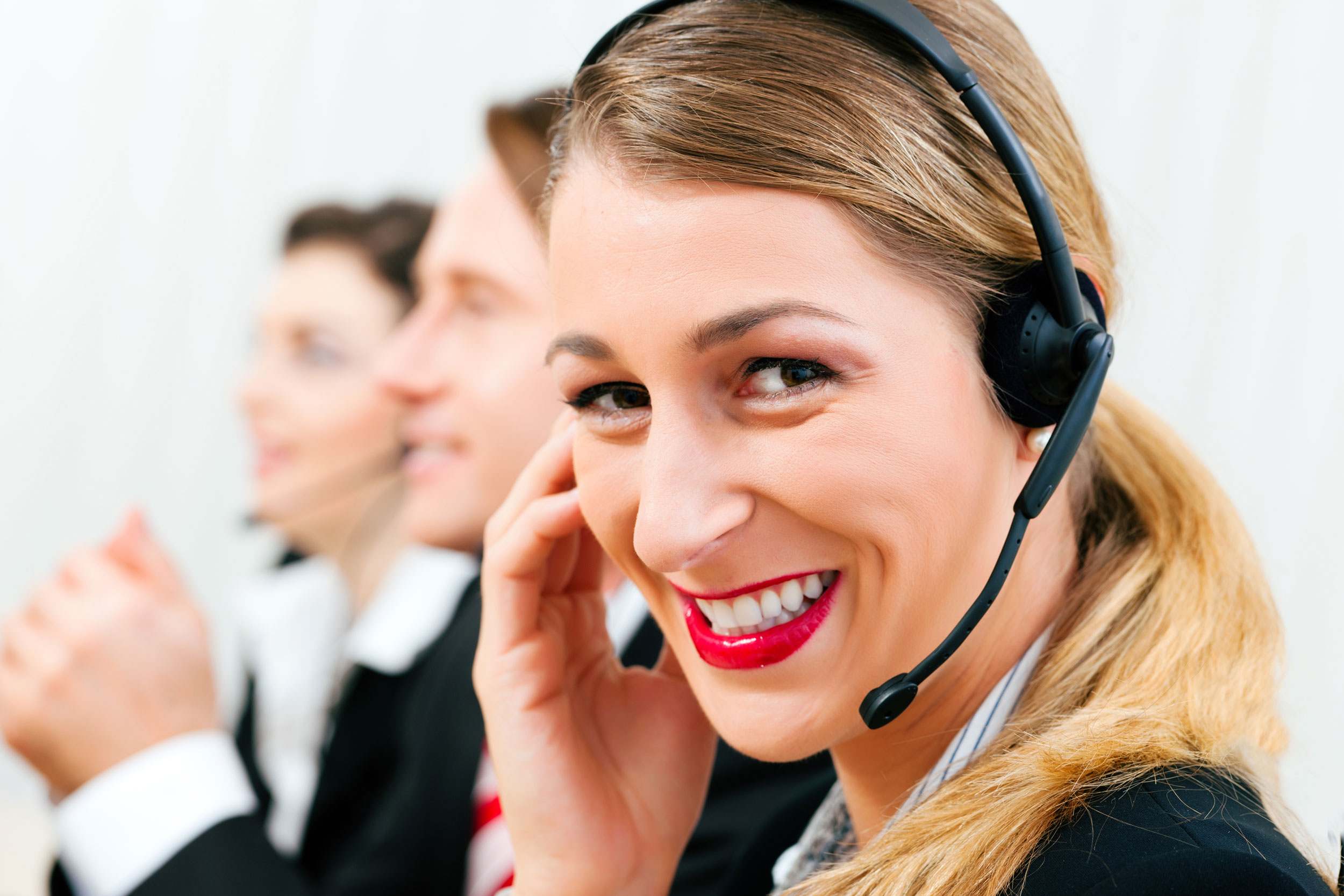 Frau im Callcenter lächelt mit Headset